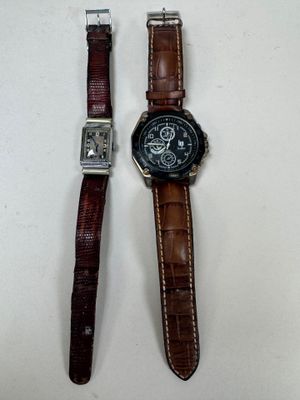 Deux montres sont posées l'une à côté de l'autre sur une surface blanche