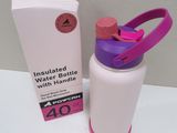 a pink and purple water bottle next to a white box
