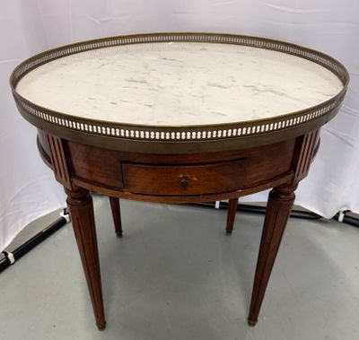 une table ronde avec un plateau en marbre et des pieds en bois