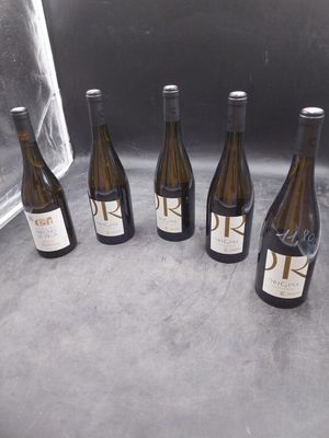 six bouteilles de vin sont alignées sur un comptoir