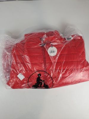 une chemise rouge emballée dans du plastique, posée sur une table blanche