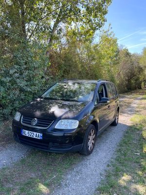 the car is parked on the side of the road near the trees