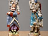 two figurines of a boy and a girl dressed in military clothing