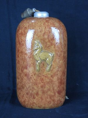 un vase marron orné d'un cheval sur fond bleu