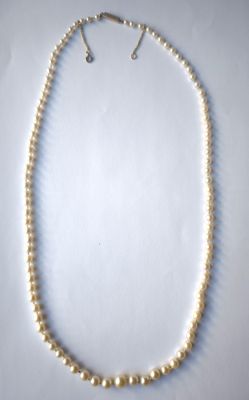 gros plan d'un collier de perles sur une surface blanche