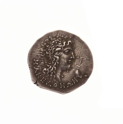 une vieille pièce de monnaie sur laquelle figure le visage d'une femme, sur un fond blanc