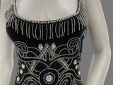 a mannequin wearing a black dress with silver beads and chains