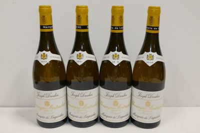 quatre bouteilles de vin sont alignées sur une table