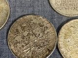 six different coins sitting on top of each other on a blue cloth