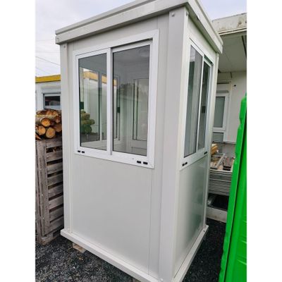 un gros plan d'un petit bâtiment blanc avec une porte verte