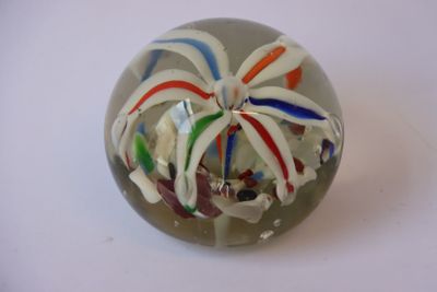 une boule de verre contenant une fleur, posée sur une table