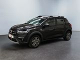 une voiture noire garée dans une pièce aux murs blancs