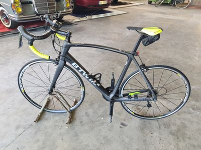 a bike that is parked in a garage next to a car