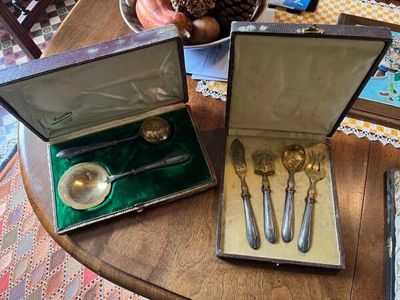 trois cuillères en argent et deux cuillères en argent dans une boîte