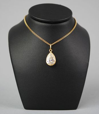un collier en or avec un pendentif en forme de larme sur un mannequin