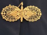 gold butterfly brooch with filigree wings on a black jacket