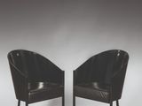une paire de fauteuils en cuir noir avec des pieds noirs sur fond blanc