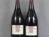 deux bouteilles de vin rouge posées sur une table en verre