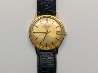 une image représentant une montre en or avec un bracelet noir