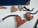 many different types of smoking pipes on the table