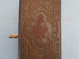 an old book with a gold trim and a flower on the cover