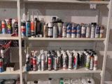 many cans of paint on the shelves in the room