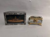 une petite boîte en argent contenant l'image d'un bateau