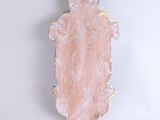 a pink object on a white surface with a blue hat on it