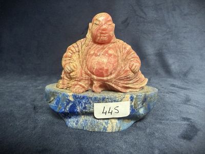 a figurine of a buddha sitting on top of a rock