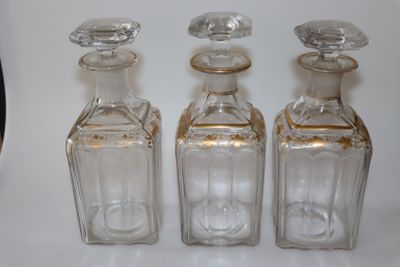 trois bouteilles en verre vides posées les unes à côté des autres sur une table