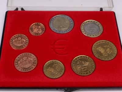 un assortiment de pièces de monnaie dans un étui rouge posé sur un fond blanc