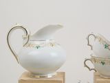 two cups and a saucer sitting on a wooden stand