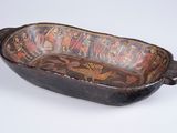 an old wooden bowl with a decorative design on it