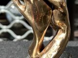 a bronze sculpture of a hand holding another hand
