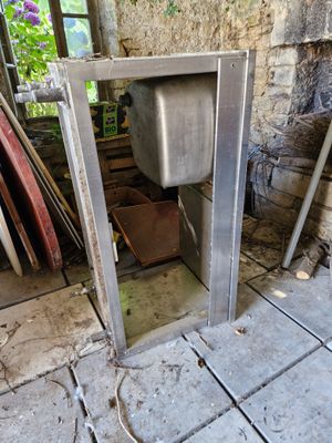 a sink in the middle of a room with a broken door