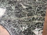 a close up of a marble table top on a wooden floor