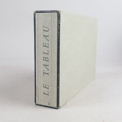 un vieux livre posé sur une table blanche à côté d'une tasse de café