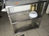 une table en acier inoxydable sur laquelle est posé un bol blanc