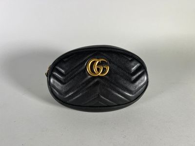 a black gucci bag with a gold gg logo on the front