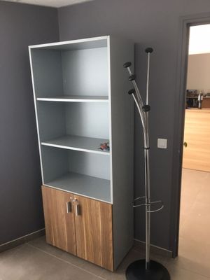 une grande bibliothèque avec un porte-manteau dans un coin de la pièce