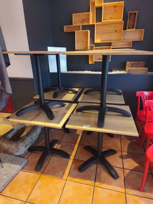 des tables et des chaises dans une pièce au sol carrelé et aux murs bleus
