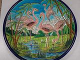 a plate with a painting of flamingos on it