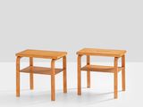 two small wooden tables sitting on top of a white surface