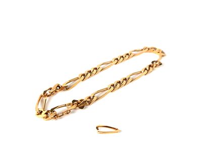 a close up of a gold chain bracelet on a white surface