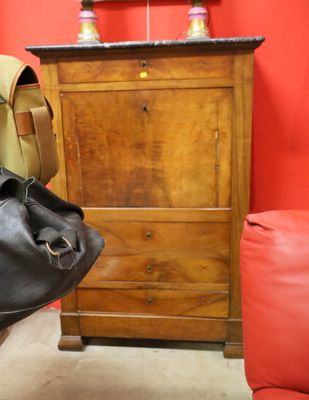 a black bag sitting next to a wooden dresser in a room