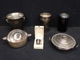 quatre casseroles et deux poêles posées sur une table