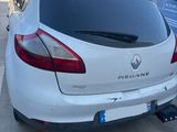 the rear end of a white car parked in a parking lot