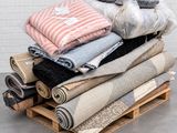 a pile of blankets and blankets on a pallet next to a wall