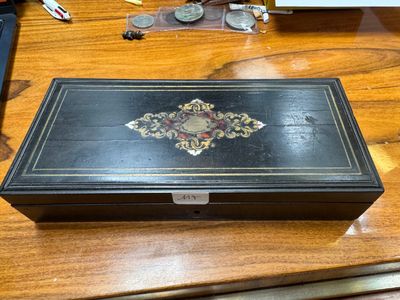 a black box sitting on a wooden table with a clock on it