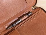 a leather case with a pen in it on a table